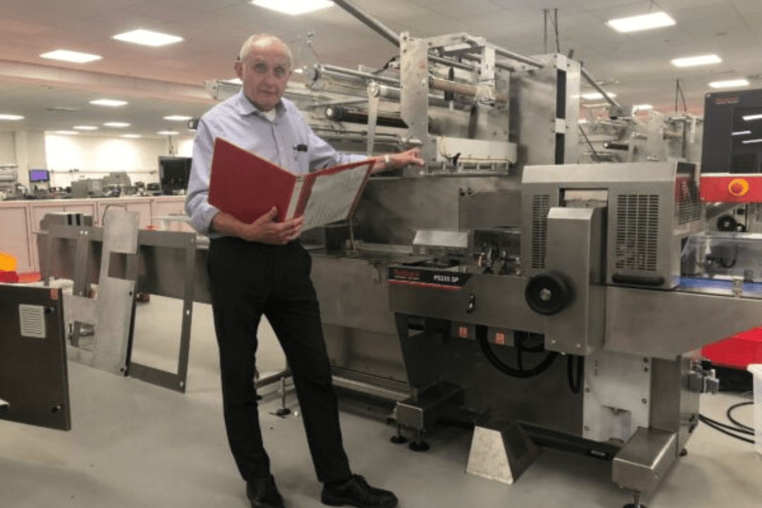 Member of the redpack team standing in front of a flow wrapping machine