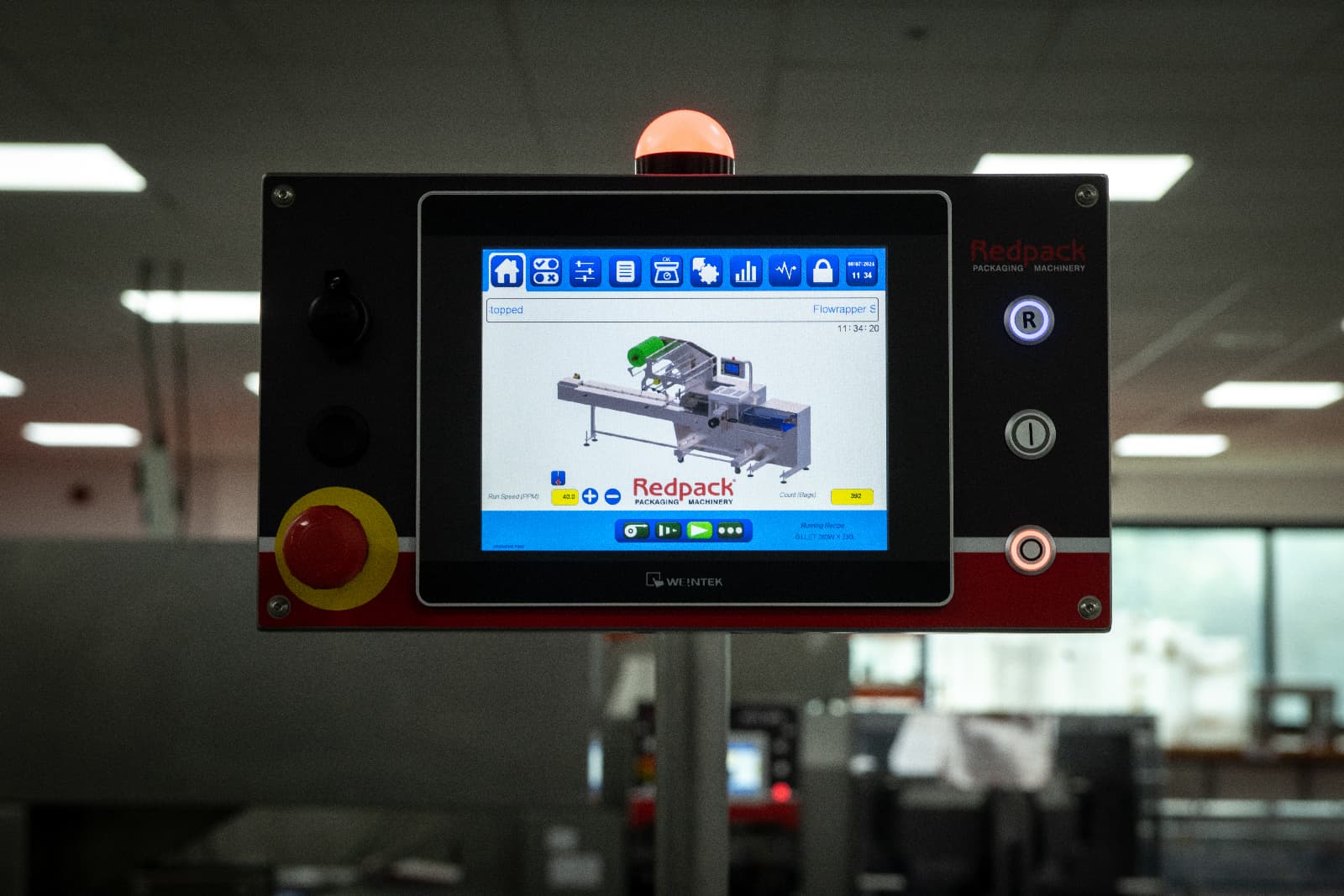 Industrial machine equipped with a display screen, used for monitoring processes in a factory setting.